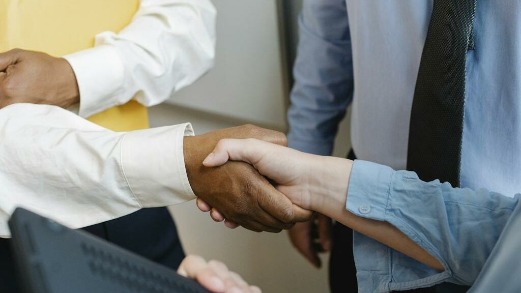 Crop anonymous diverse entrepreneurs shaking hands after meeting and negotiating about new project