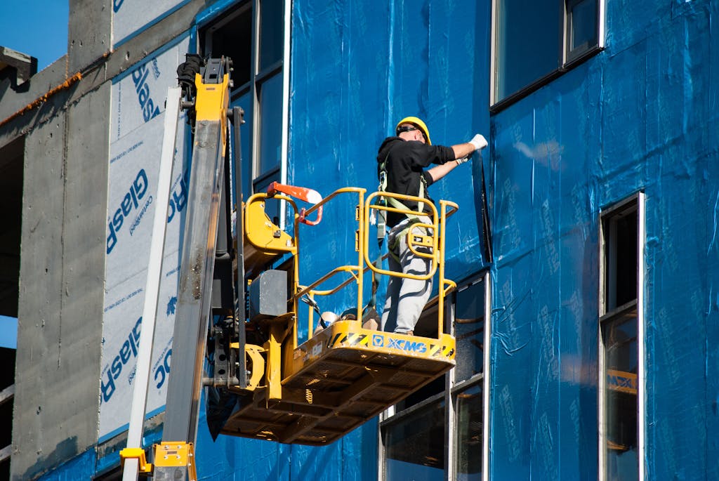 Man in Black Jacket and Black Pants Riding Yellow and Black Heavy Equipment